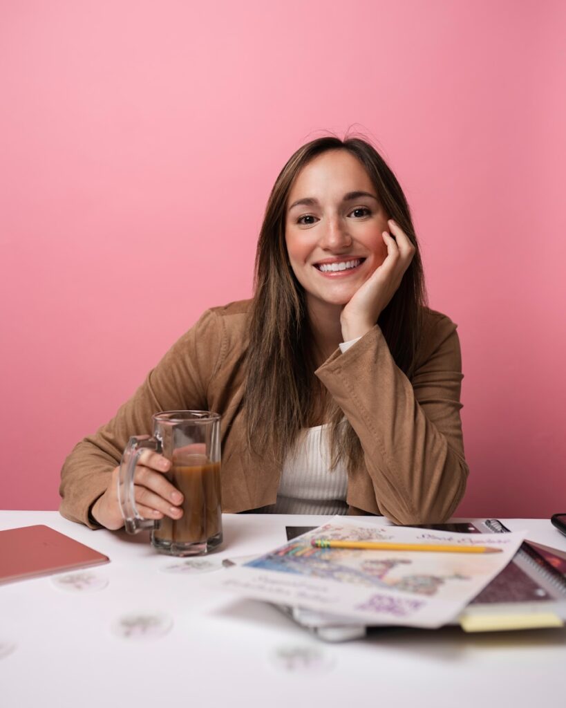 a woman sitting at a table with a glass of coffee